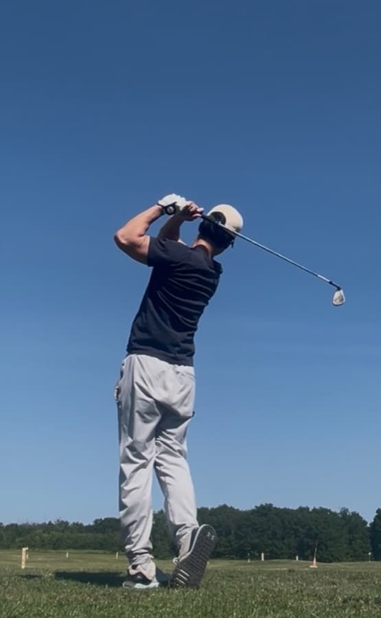 Golfer mid-swing on the course